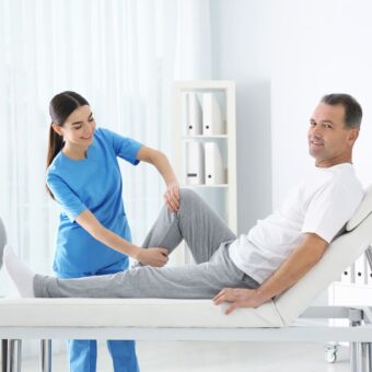 Masseur kinésithérapeute qui manipule la jambe d'un patient