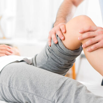 Kinésithérapeute qui manipule la jambe d'un patient