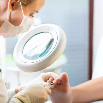 Pedicure podologue qui examine le pied d'un patient