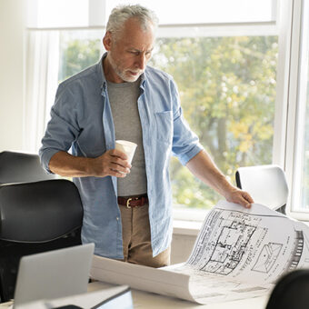 Architecte qui consulte ses plans dans sonbureau