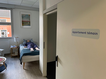 Appartement témoin avec un mannequin d'une femme âgée sur un lit