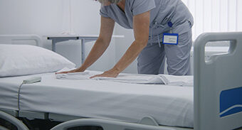 Agent de services hospitaliers qui nettoie une chambre